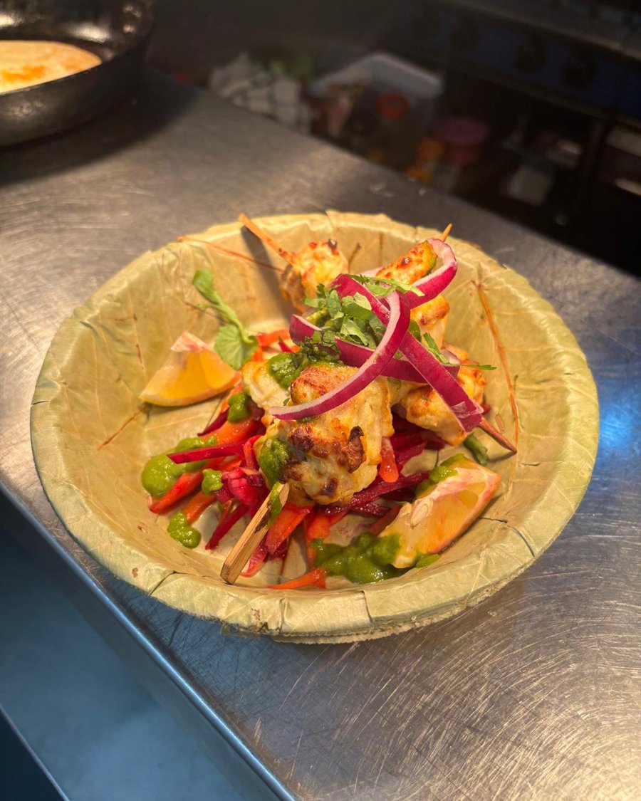 Chargrilled skewers with green chutney, served in a leaf bowl